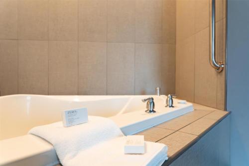 a bath tub with two towels and a mirror at Hampton Inn Turnersville in Blackwood