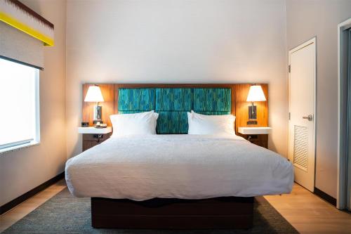 a bedroom with a large bed with two tables and two lamps at Hampton Inn Turnersville in Blackwood