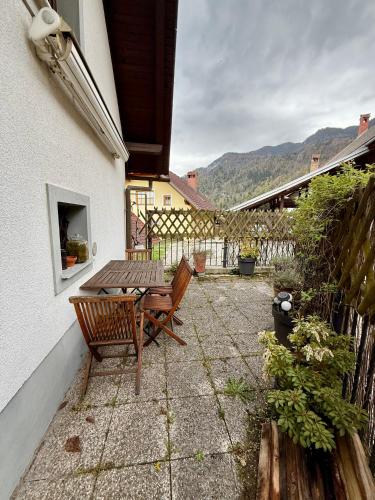 a patio with a wooden table and a bench at Katja Cottage in Bohinjska Bela