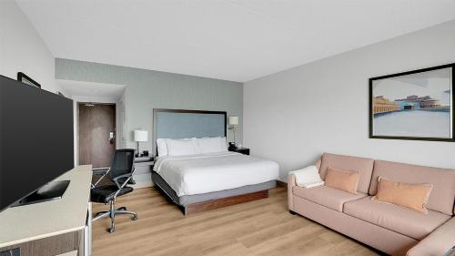 a hotel room with a bed and a couch at Hampton Inn & Suites by Hilton Toronto Markham in Markham
