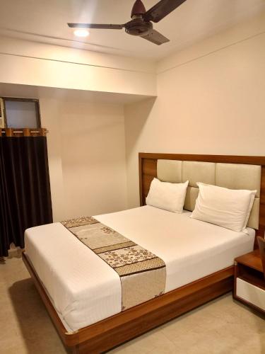 a bedroom with a bed with a ceiling fan at Hotel Diamora Residency in Thane