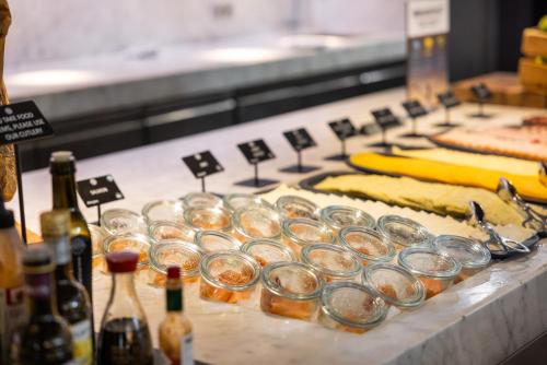 a buffet line with jars of food and bottles of beer at Pullman Eindhoven Cocagne in Eindhoven