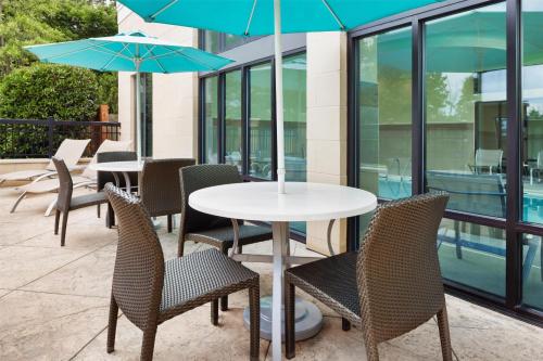 a table and chairs with umbrellas on a patio at Hampton Inn & Suites Chattanooga/Hamilton Place in Chattanooga