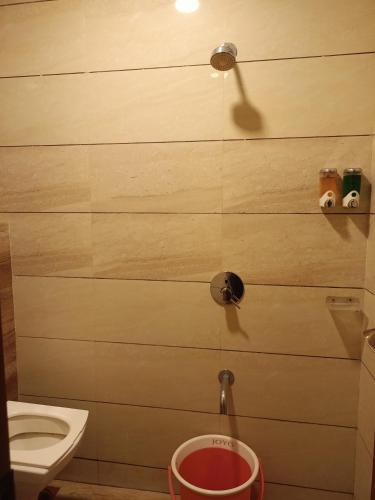 a bathroom with a toilet and a bucket at Hotel Diamora Residency in Thane