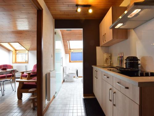 a kitchen with wooden cabinets and a dining room at Apartment in Champlon Ardenne in Champlon