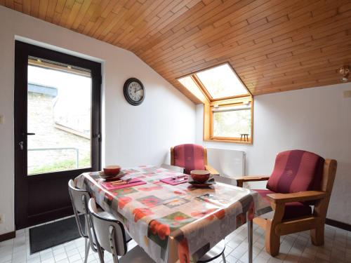 a dining room with a table and chairs and a clock at Apartment in Champlon Ardenne in Champlon