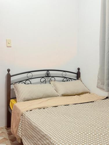 a bedroom with two beds and a white wall at Dive House by Casita del Mabini in Mabini