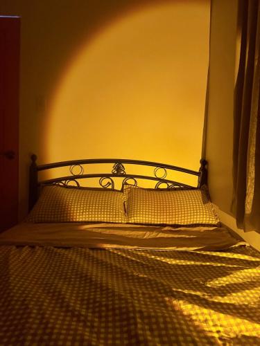 a bed in a room with a yellow wall at Dive House by Casita del Mabini in Mabini