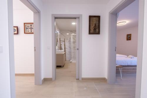 a hallway with white walls and a bedroom with a bed at Villa Montês - Exclusive Apartments & Prime Location in Coja