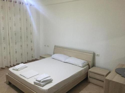 a bedroom with a white bed with towels on it at Cold Water Residence in Vlorë