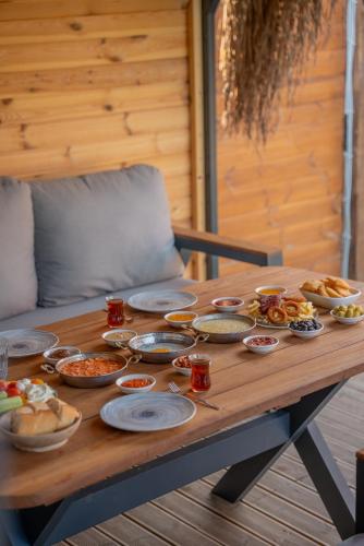 YanıkArmoni Life Bungalov的一张木桌,上面放着许多盘子的食物