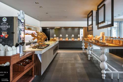 a restaurant kitchen with a counter with food at Pullman Eindhoven Cocagne in Eindhoven