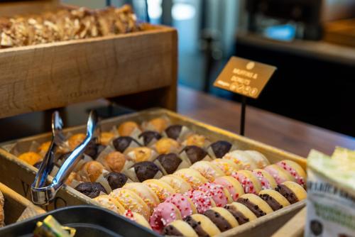 a display of different types of donuts and pastries at Pullman Eindhoven Cocagne in Eindhoven