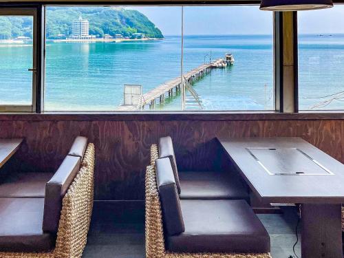 a table and chairs with a view of the ocean at Sea Tiger Island Inn Shodoshima in Shodoshima