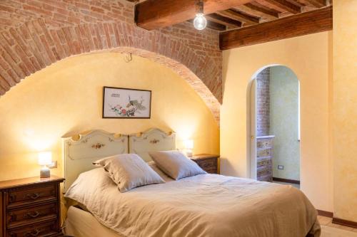 ein Schlafzimmer mit einem großen Bett mit Ziegelwand in der Unterkunft Tuscany - Townhouse - Sleeps 18 - Garden near Lake in Gioiella