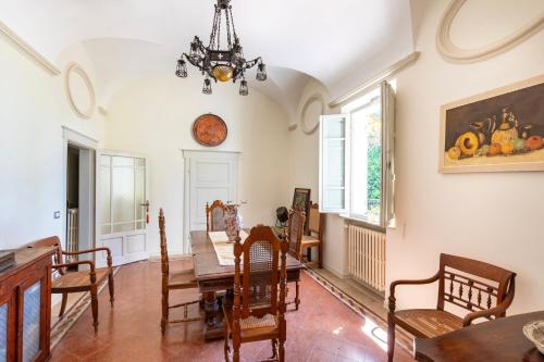 ein Esszimmer mit Tisch und Stühlen und einer Uhr in der Unterkunft Tuscany - Townhouse - Sleeps 18 - Garden near Lake in Gioiella