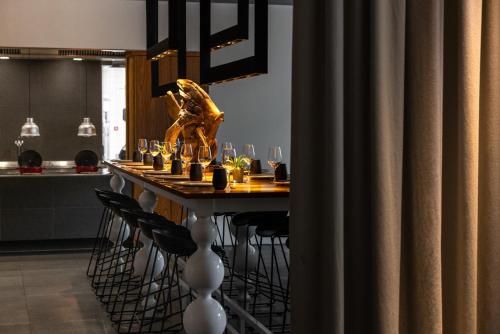 a table with wine glasses and a statue on it at Pullman Eindhoven Cocagne in Eindhoven