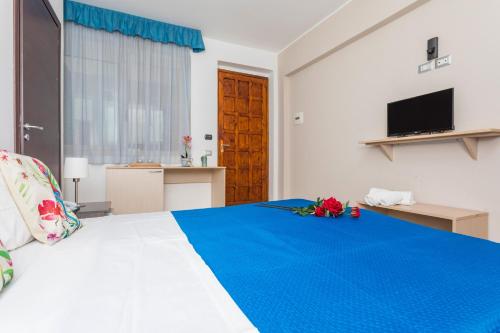 a bedroom with a large bed with a blue blanket at Sirina Tao Beach in Taormina