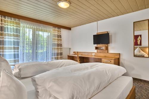 a bedroom with two beds and a tv on a wall at Gasthof Pension Fischerstüberl in Blaibach