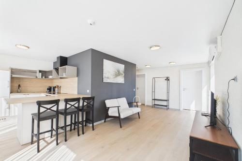 AizkraukleにあるModern Apartment in Aizkraukleのキッチン、リビングルーム(バー、椅子付)