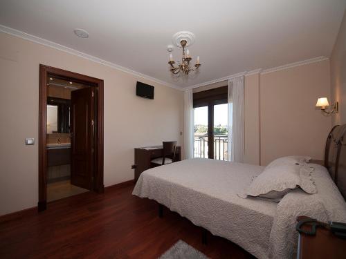 a bedroom with a bed and a window at Pensión Residencia A Cruzán in Noalla