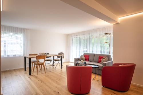 a living room with a couch and a table at Zuhause in den Alpen Ihre Ferienwohnung mit Hallenbad und Sauna in Lenzerheide