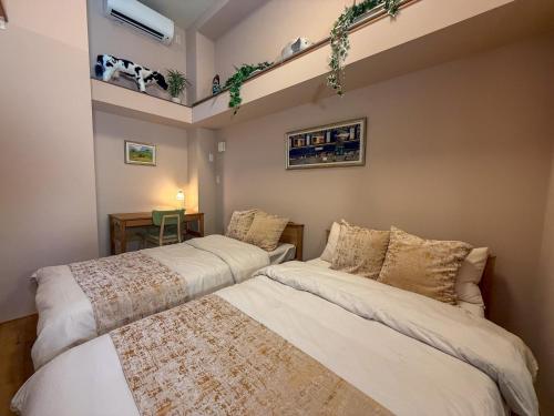 two beds in a small room with a tv at ケイアイコンホテルズプロパンズ in Nagoya