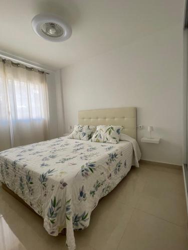a bedroom with a bed with a floral bedspread at Cris Sol 205 in Arona