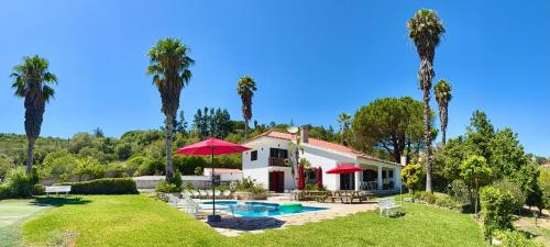 a house with a swimming pool and palm trees at Casa Calidris - Bed, Wine & Breakfast in Sesimbra