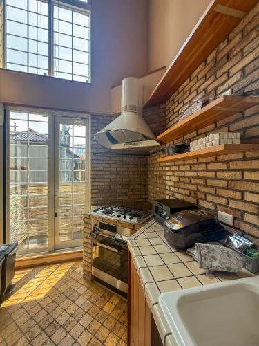 a kitchen with a stove top oven next to a sink at ケイアイコンホテルズプロパンズ in Nagoya