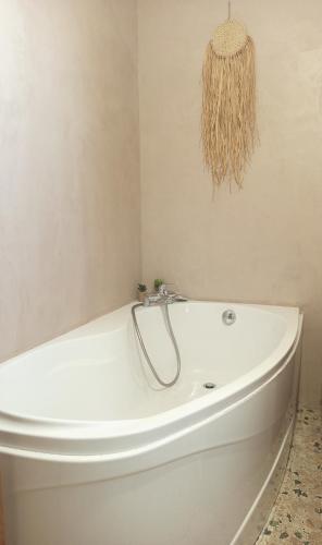 a white bath tub sitting in a bathroom at La Cabane des Mouts- Piscine -Clim in Fleury