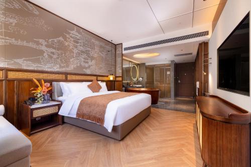 a hotel room with a bed and a television at Wingate by Wyndham Yunfu Xinxing in Yunfu