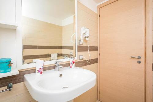 a bathroom with a white sink and a mirror at Sirina Tao Beach in Taormina