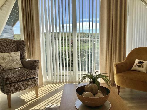 a living room with a table and a large window at Larchwood Lodge in Ellon