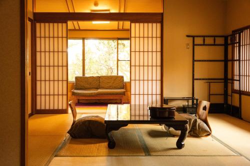 a living room with a table and a couch at Kotonoyado Musashino in Nara