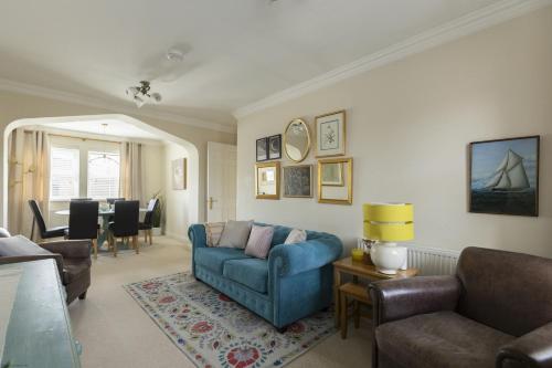 a living room with a blue couch and chairs at Castle Mill View in Oxford