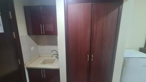 a bathroom with wooden cabinets and a sink at فندق جوهرة الشروق in Az Zahrāʼ