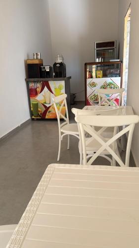 a room with two white chairs and a table at Appartement avec jardin route Saïdia in Berkawe