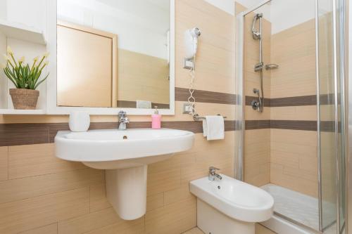 a bathroom with a sink and a mirror and a toilet at Sirina Tao Beach in Taormina