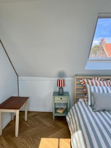 a bedroom with a bed and a table and a window at The Blue Loft in Anstruther