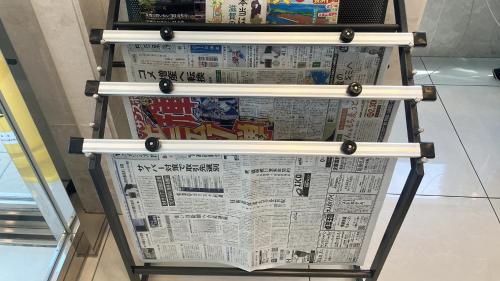 a newspaper rack with two newspapers on it at Toyoko Inn Maibara eki Shinkansen Nishi guchi in Maibara