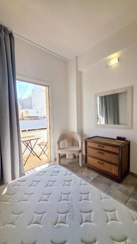 a bedroom with a bed and a dresser and a window at Citycenter Comfy Apartment in Larnaca