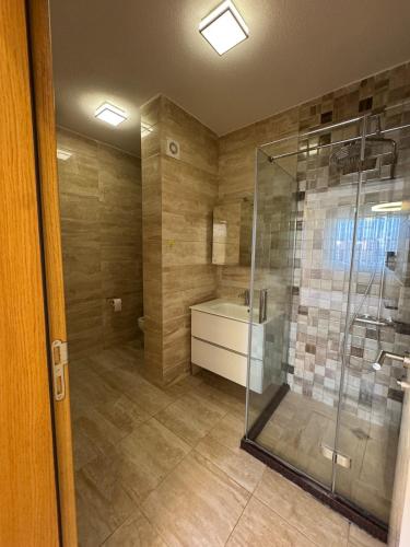 a bathroom with a shower and a bath tub at Riga Lux Apartment Prishtina in Pristina