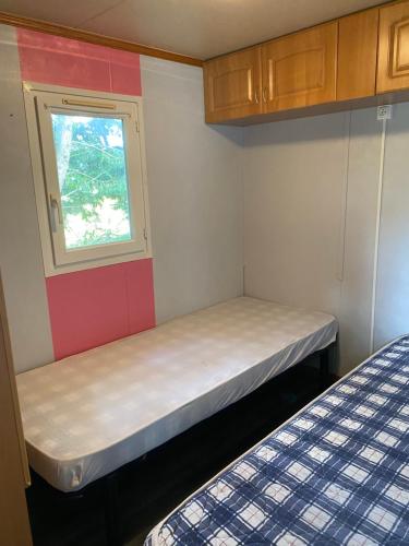 a small room with a bed and a window at Mobil-home 3 chambres in Souvigné