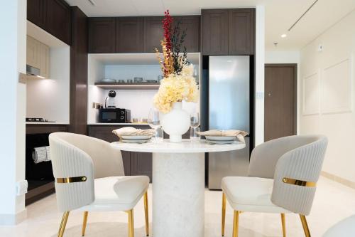 a dining room table with chairs and a vase with flowers at KeyRock - Dubai Marina Stay with Pool & Gym in Dubai
