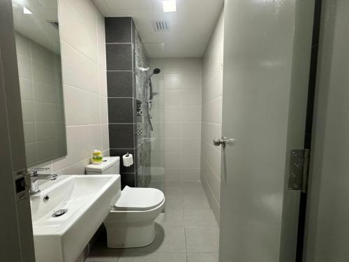 a white bathroom with a toilet and a sink at Alinea suites DSM near by shah alam in Shah Alam