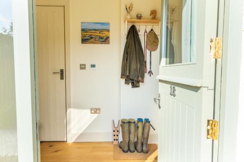 a hallway with a door and boots on the floor at The Little Stable - Cosy 1 Bed Cottage in Burford in Swinbrook