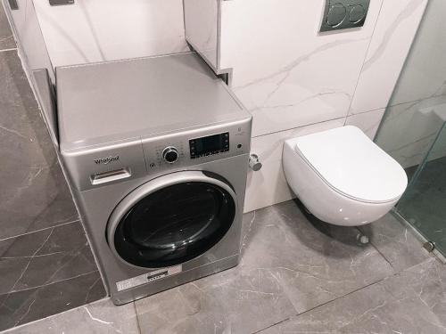 a washing machine in a bathroom with a toilet at Legit Luxury Apartment at Accra KASS Towers in Accra