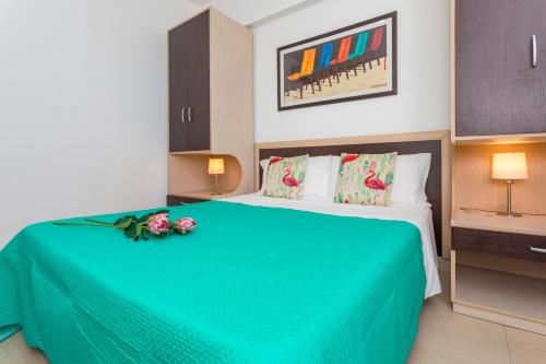 a bedroom with a green bed with flowers on it at Sirina Tao Beach in Taormina