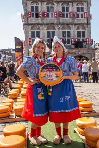 two women standing next to each other holding a frisbee at Gouda city center apartment with private garden and 2 bicycles in Gouda
